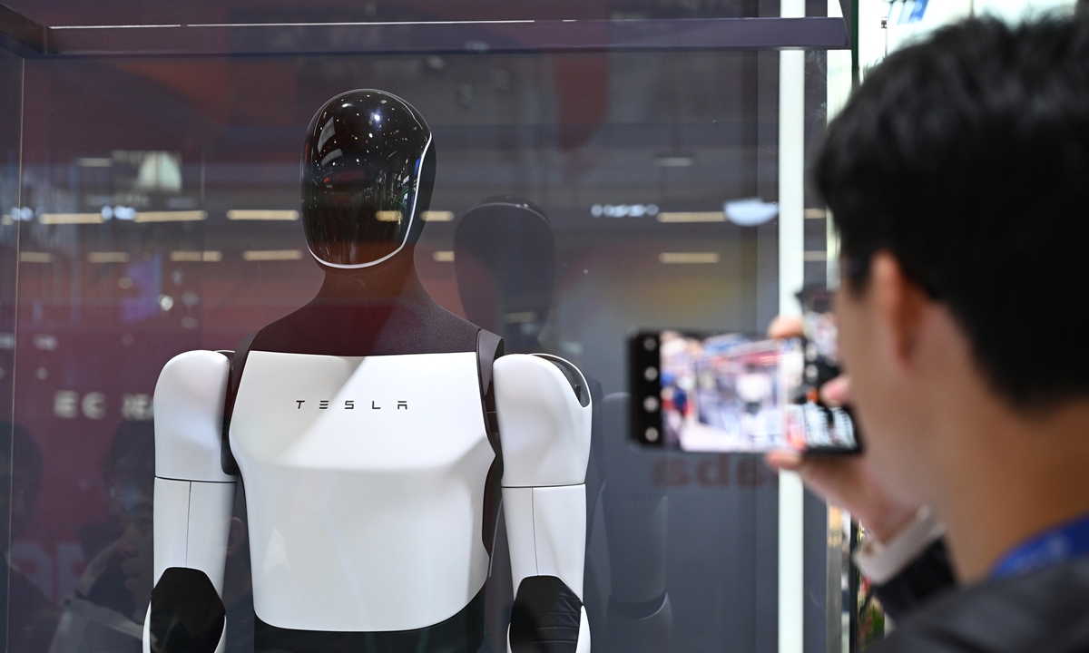 An expo visitor takes picture of a Tesla humanoid robot on display at the 2nd China International Supply Chain Expo (CISCE) in Beijing on November 27, 2024. Photo: Chen Tao/GT